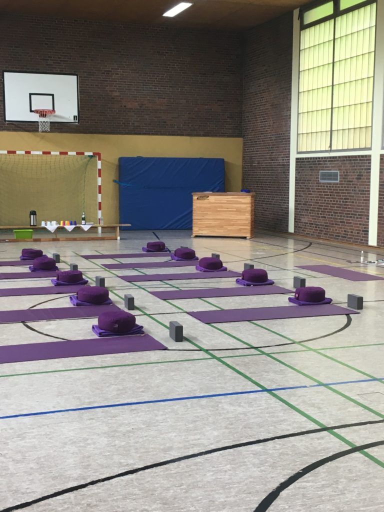 Vorbereitete Yogamatten mit Blöcken in einer Turnhalle