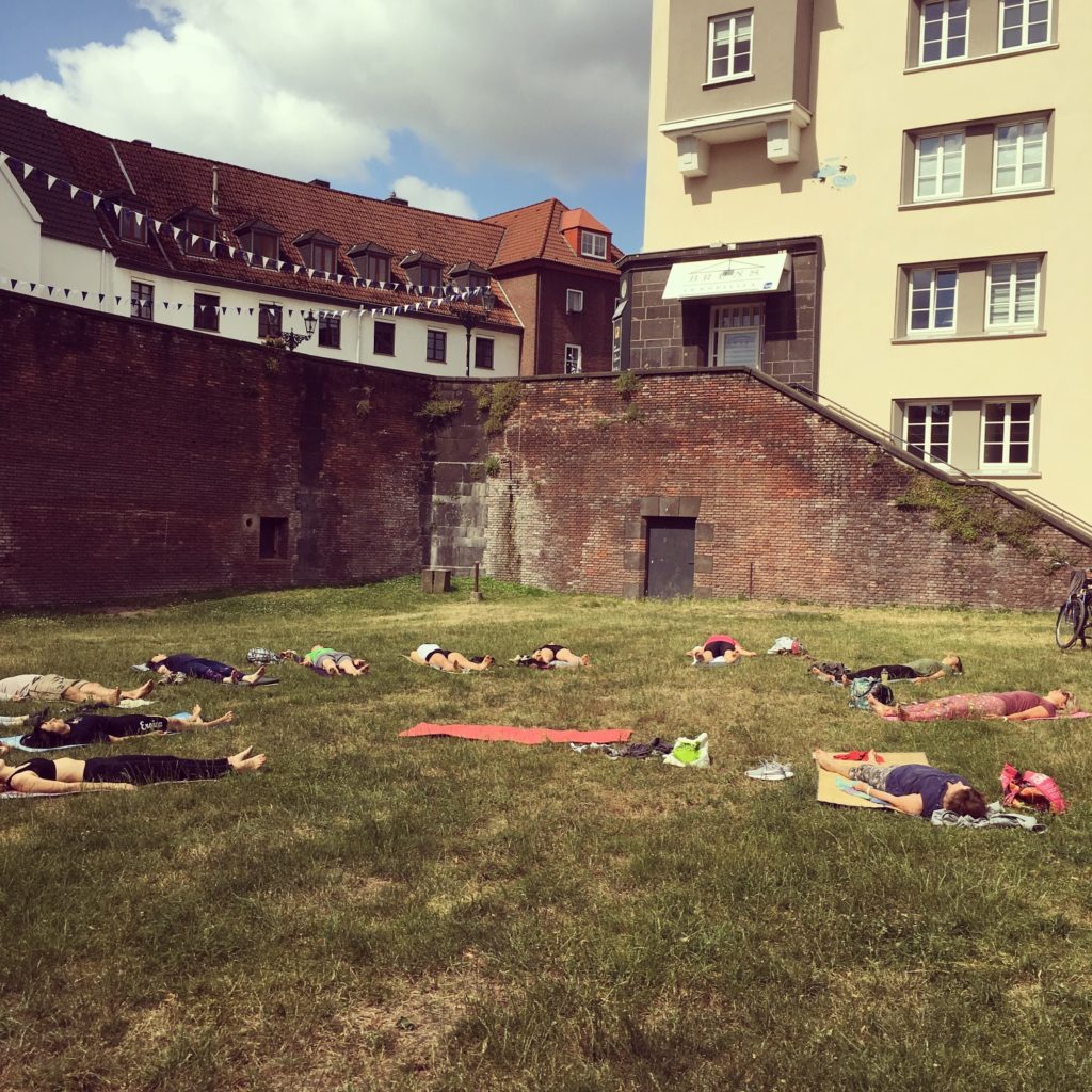 Yogamatten auf einer Wiese vor historischen Mauern