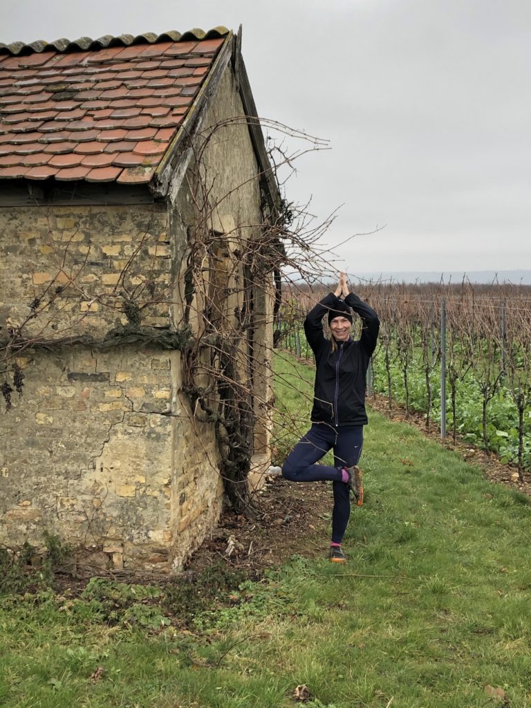 Frau in Baumhaltung vor einem alten Steinhäuschen im Weinberg