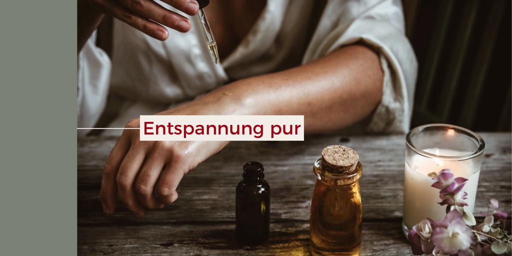 Hände bei einer Massage mit Öl und Kerze – Entspannung pur