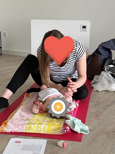 Mutter massiert die Füße ihres Babys im Babymassage-Kurs