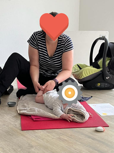 Mutter massiert die Beine ihres Babys im Babymassage-Kurs